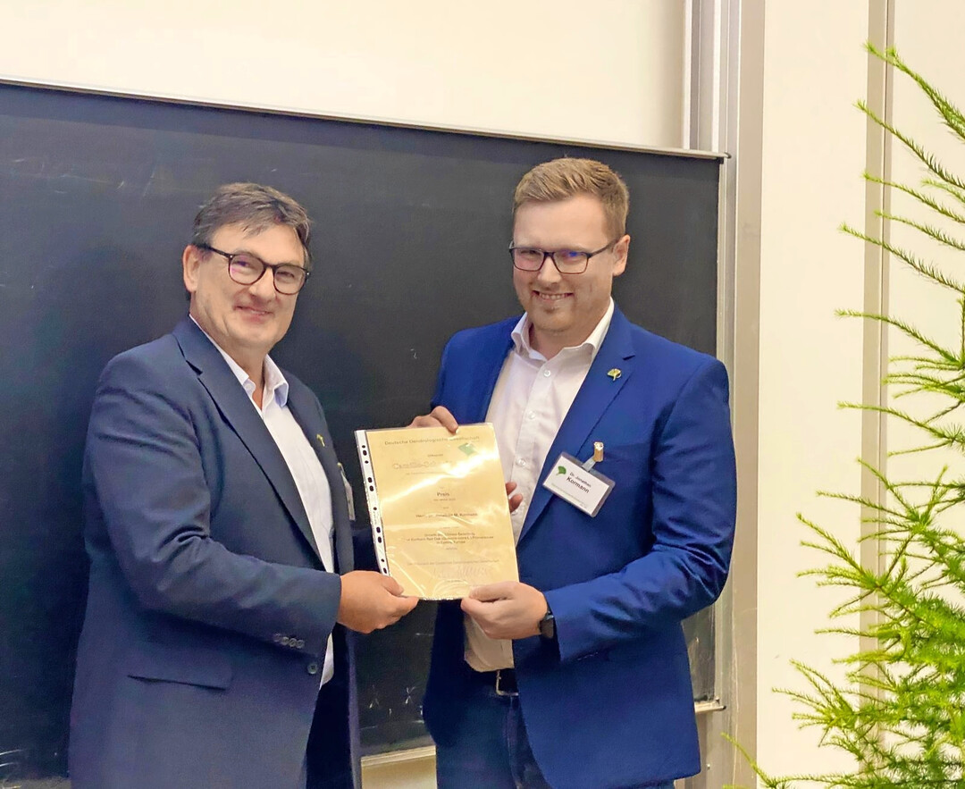 Gleich an zwei Forschende wurde der Camillo Schneider Preis 2025 verliehen: Eike Jablonski bergibt die Urkunde an Dr. Jonathan Kormann (re.) und an Dr. Katharina Liepe (bei der Preisverleihung nicht anwesend). 