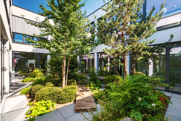 Im Mitarbeitergarten wurden gro�e B�ume gepflanzt, damit sich die Innenh�fe nicht so stark aufheizen.