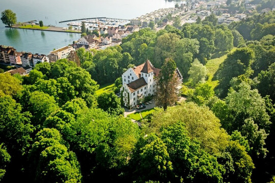 Auf der Schweizer Seite des Bodensees liegt Schloss Wartegg, umgeben von altem Baumbestand.