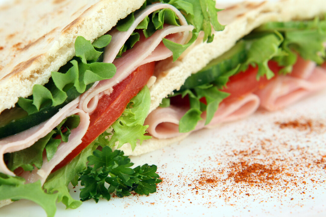 A closeup macro photo of a colorful sandwich with a shallow DOF on white