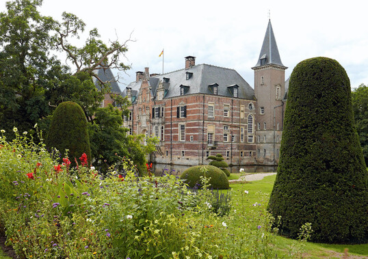 Gepflegte Sommerblumenbeete und formierte Eiben und Buchsgehlze prgenden Bereich nahe dem Wasserschloss.
